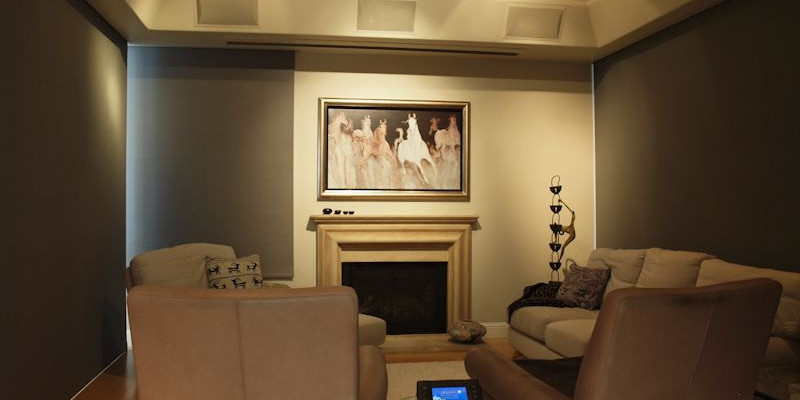 Marin Custom Home Theater-Showing a picture of the art work hiding the plasma with two of the light block shades rolled down. Controlled by the Crestron touch panel on the table.